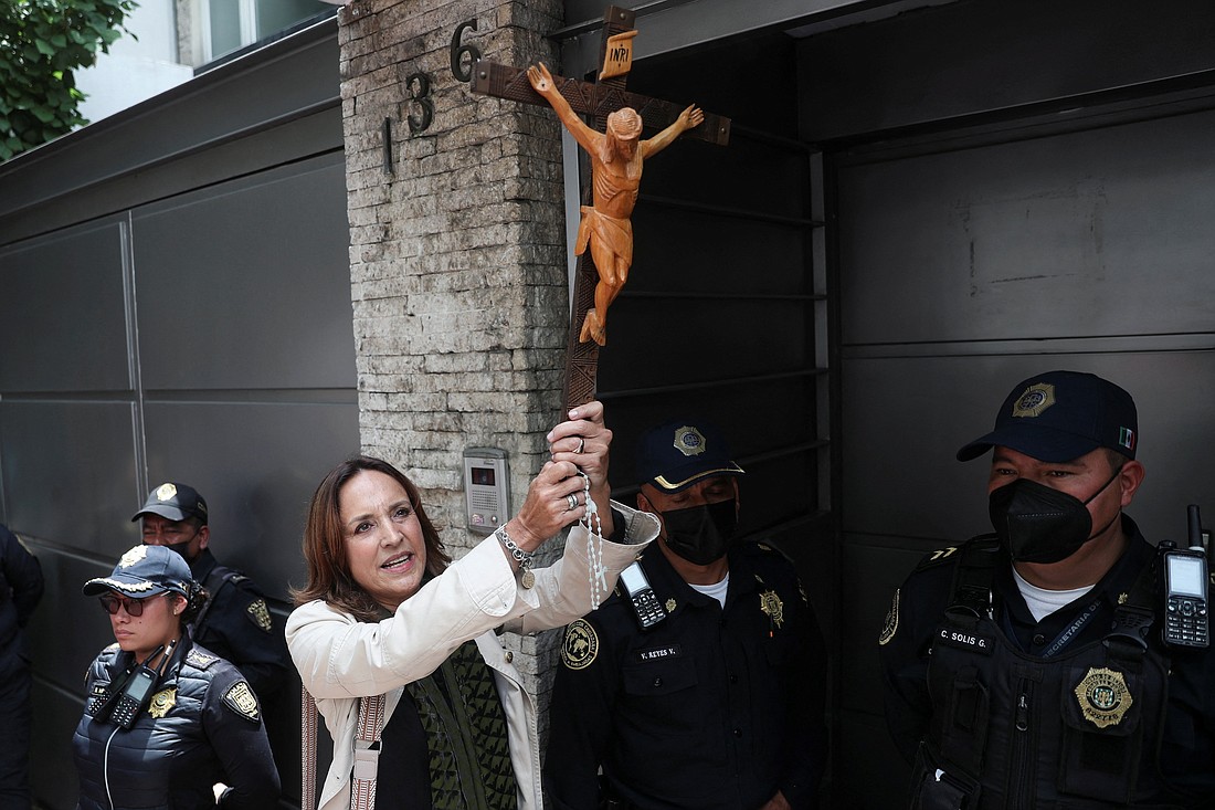 A woman holds a crucifix outside the Nicaraguan Embassy in Mexico City Aug. 16, 2022, as she takes part in a protest to demand respect for religious freedom and an end to the persecution of the Catholic Church and the opponents of the government of Nicaraguan President Daniel Ortega. (OSV News photo/Edgard Garrido, Reuters)