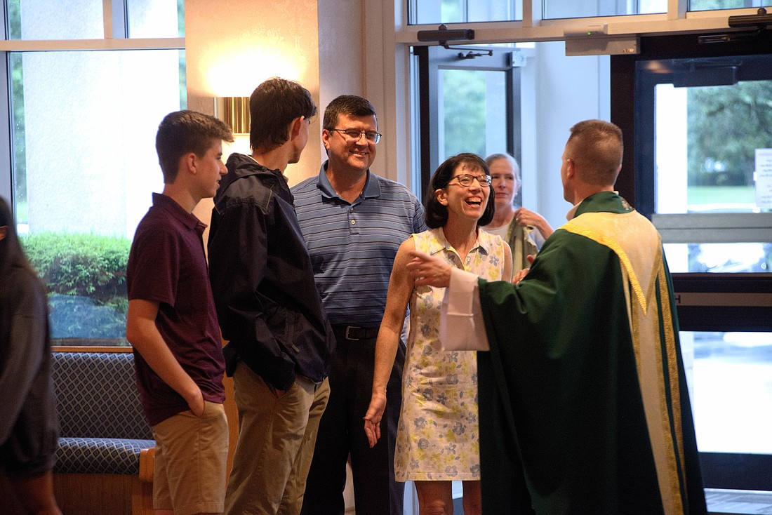 Father Jason Parzynski, administrator in St. David the King Parish, Princeton Junction, greets parishioners arriving for the 7 p.m. "Post Beach/Last Chance Mass" on July 16. Joe Moore photo