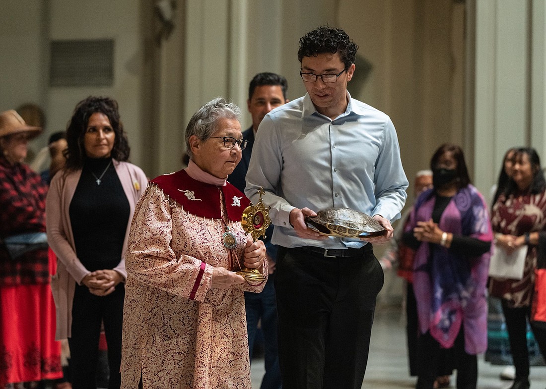 Sister Kateri Mitchell, a member of the Sisters of St. Anne, carries a relic of St. Kateri Tekakwitha, and Jake Finkbonner of Ferndale, Wash., carries a turtle shell as they process into St. James Cathedral in Seattle Oct. 22, 2022, for a Mass celebrating the 10th anniversary of St. Kateri's canonization. Jake was 6 years old when he was healed of flesh-eating bacteria the day after Sister Kateri placed a Kateri relic on him and joined Jake's mother in praying for him. His recovery was the second miracle needed to elevate then-Blessed Kateri to sainthood. (OSV News photo/Stephen Brashear, Northwest Catholic)