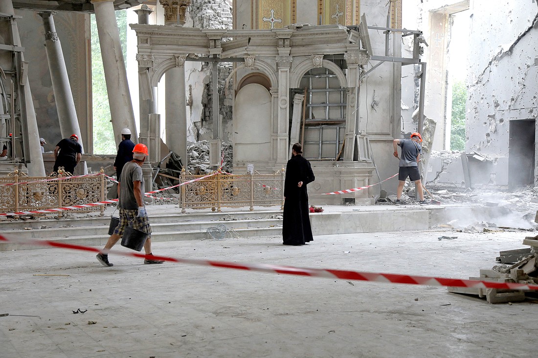Volunteers remove debris while an Orthodox priest prays inside the Holy Transfiguration Cathedral (Spaso-Preobrazhensky Cathedral) in Odesa, Ukraine, July 23, 2023, after it was damaged during a Russian missile strike. The attack partially destroyed the historic Ukrainian Orthodox cathedral and UNESCO World Heritage site, prompting international outrage and pledges to rebuild. (OSV News photo/Nina Liashonok, Reuters)