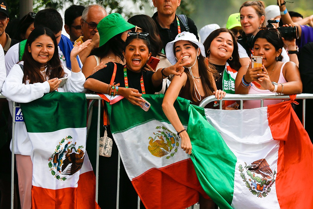 A group of young people holding Mexican flags gather outside the Belém Cultural Center to welcome Pope Francis to Lisbon, Portugal, Aug. 2, 2023. The pope began a five-day trip to Portugal to participate in World Youth Day. (CNS photo/Lola Gomez)