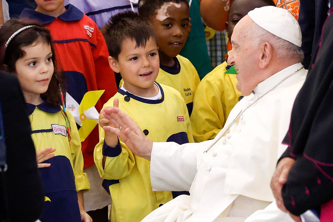 Pope Francis greets children after meeting with representatives of local charities at the parish center in Serafina, a neighborhood in Lisbon, Portugal, Aug. 4, 2023. (CNS photo/Lola Gomez)