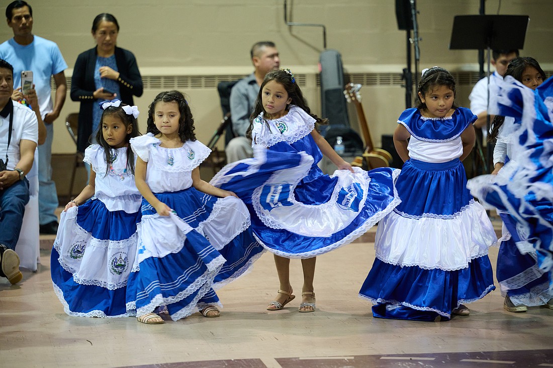 Dressed in the colors of their native country, young El Salvadoran parishioners present a dance during the festival for the Feast of the Divine Savior of the World in Holy Trinity Church, Long Branch, Aug. 5. Mike Ehrmann photo