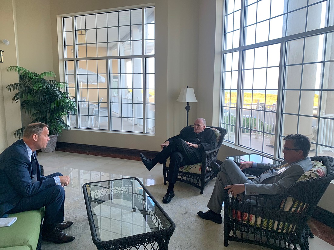 During the CUA alumni gathering, Bishop O'Connell, center, chats with Scott Reimbold, the university's vice president for development, left, and Dr. Peter Kilpatrick, president, at right. Staff photo