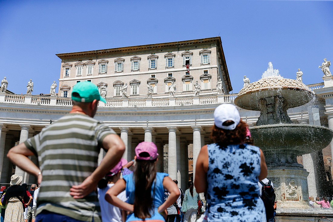 People look up to the Apostolic Palace as Pope Francis leads the recitation of the Angelus with visitors gathered in St. Peter's Square at the Vatican Aug. 15, 2023. (CNS photo/Lola Gomez)