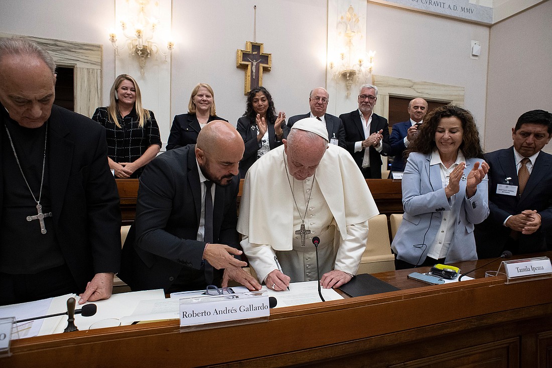 Pope Francis signs a document establishing the Pan-American Committee of Judges for Social Rights and Franciscan Doctrine in this file photo from a meeting in the headquarters of the Pontifical Academy for Social Sciences at the Vatican June 4, 2019. To the left of the pope is Roberto Andrés Gallardo, a judge in Buenos Aires, whom Pope Francis named president of the committee when he erected it as an international public association of the faithful. (CNS photo/Vatican Media)