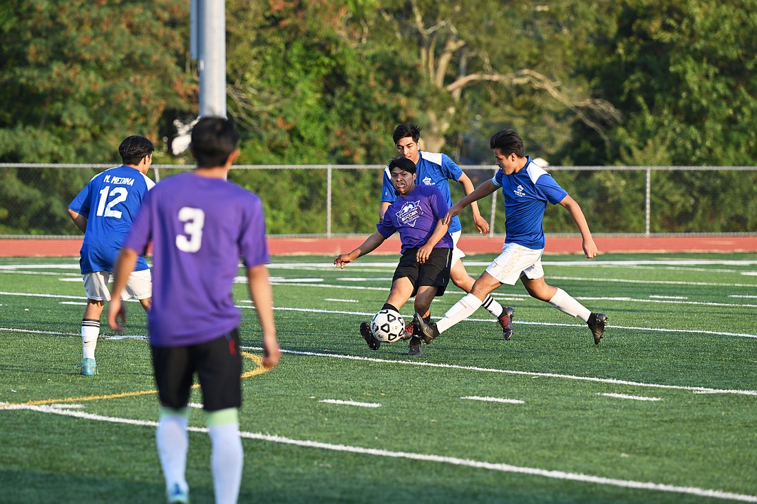 Soccer team members from St. Anthony of Padua Parish, Hightstown, and St. Rose of Lima Parish, Freehold, battle for the ball in the Pastor's Cup. Mike Ehrmann photo
