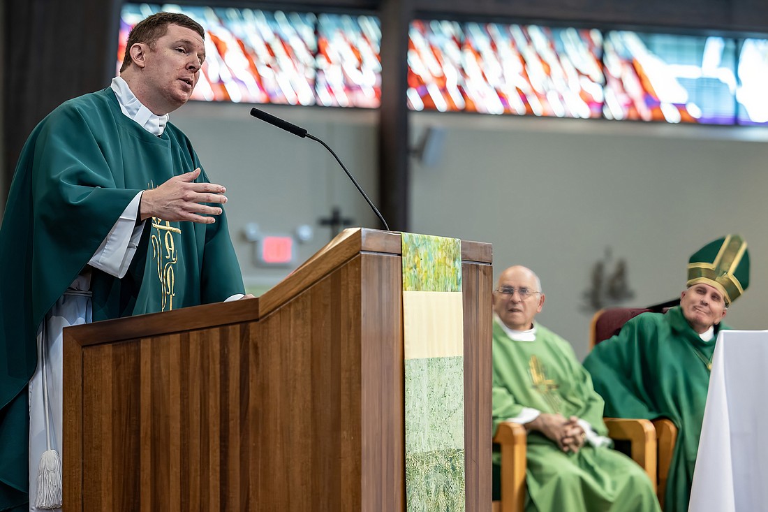 Bishop O'Connell and Deacon Joe DeLuca look on as Father McClane preaches his homily. Hal Brown photo