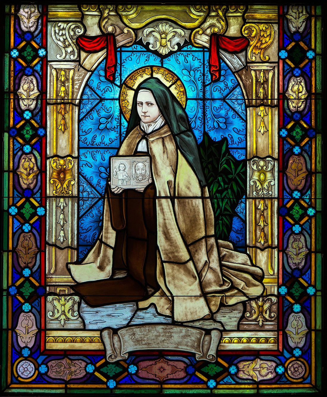 A stained glass window inside St. Thérèse Chapel at Holy Hill in Hubertus, Wis., depicts St. Therese with pictures of the child Jesus and the "holy face." The day she received the habit on Jan. 10, 1889, she signed her name for the first time as "Sister Thérèse of the Child Jesus and the Holy Face." (OSV News photo/Sam Lucero).