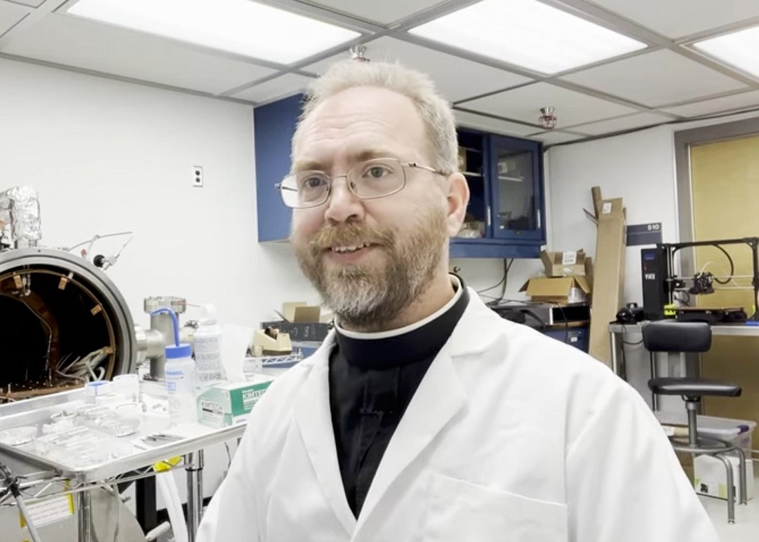 Jesuit Brother Robert Macke presents a device to study the porosity and density of specimens retrieved from the asteroid Bennu by the Osiris-Rex space mission at the Lunar and Planetary Laboratory in Tucson as seen in a YouTube video he posted on his channel Aug 12, 2022. (CNS photo/YouTube video screenshot)