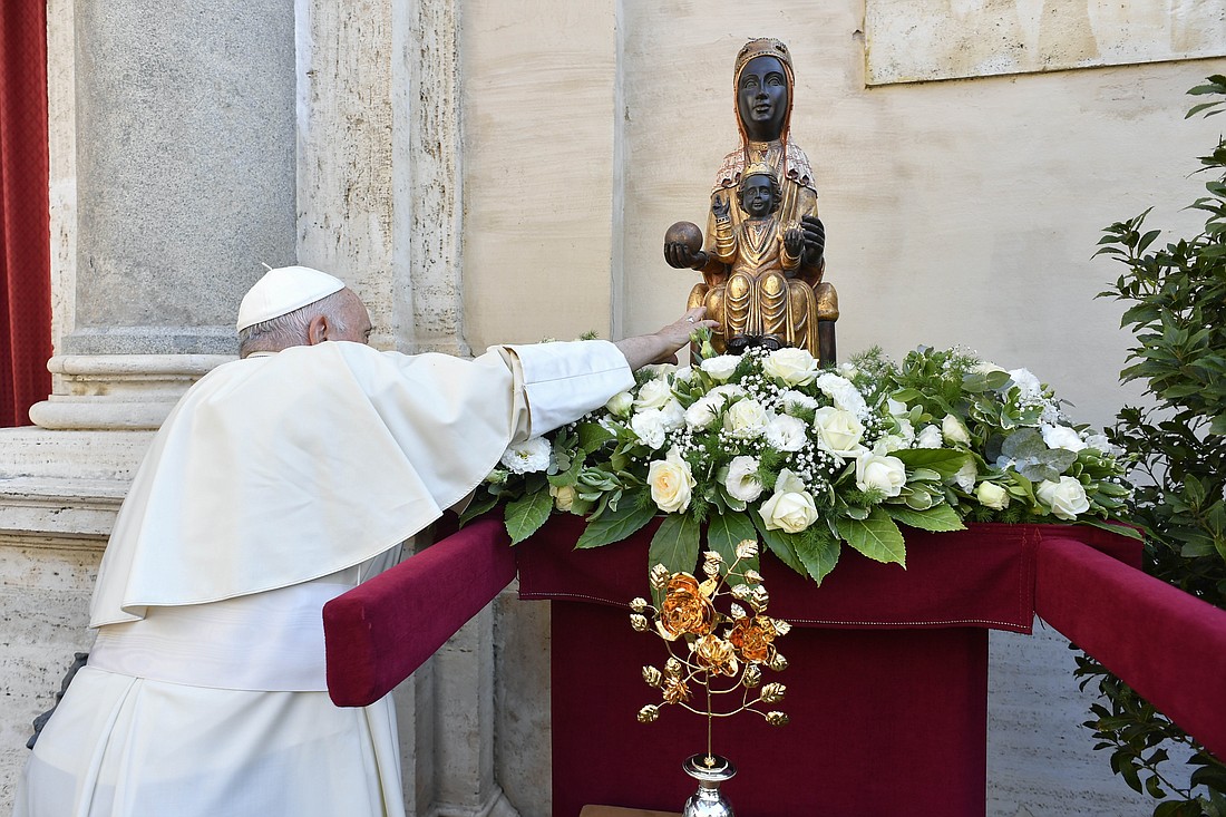 Pope Francis reaches out to touch a statue of Our Lady of Montserrat during an audience with pilgrims marking the 800th anniversary of the Confraternity of Our Lady of Montserrat Oct. 7, 2023, in the San Damaso Courtyard of the Apostolic Palace at the Vatican. (CNS photo/Vatican Media)