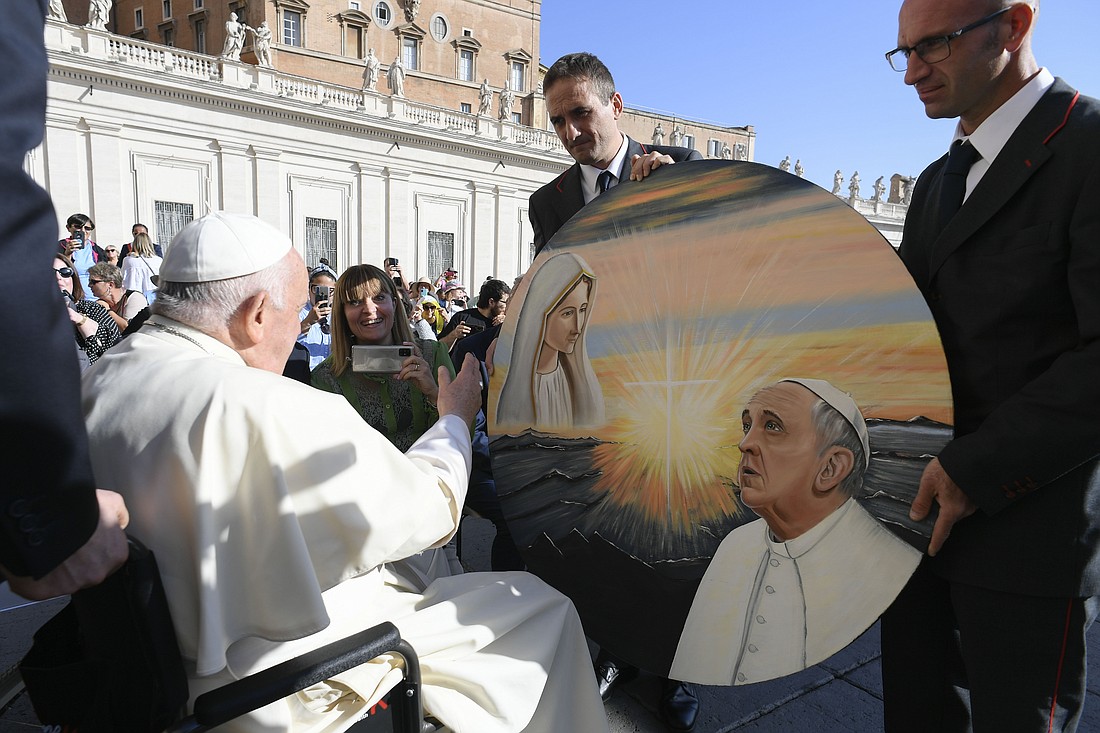 Pope Francis is given a painting of himself and the Virgin Mary after his weekly general audience in St. Peter's Square at the Vatican Oct. 11, 2023. (CNS photo/Vatican Media)