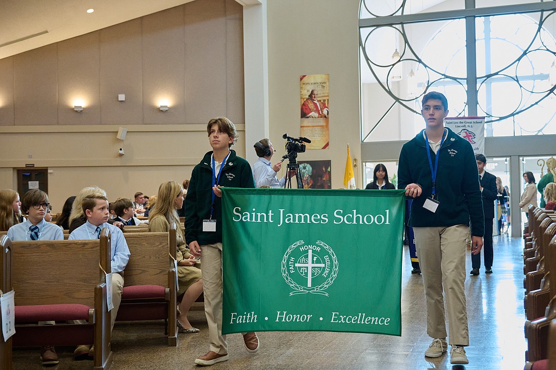 Representatives from St. James School, Red Bank, carry their school banner during the procession at the start of the Oct. 12 Catholic Schools Mass in St. Robert Bellarmine Co-Cathedral, Freehold. Mike Ehrmann photo