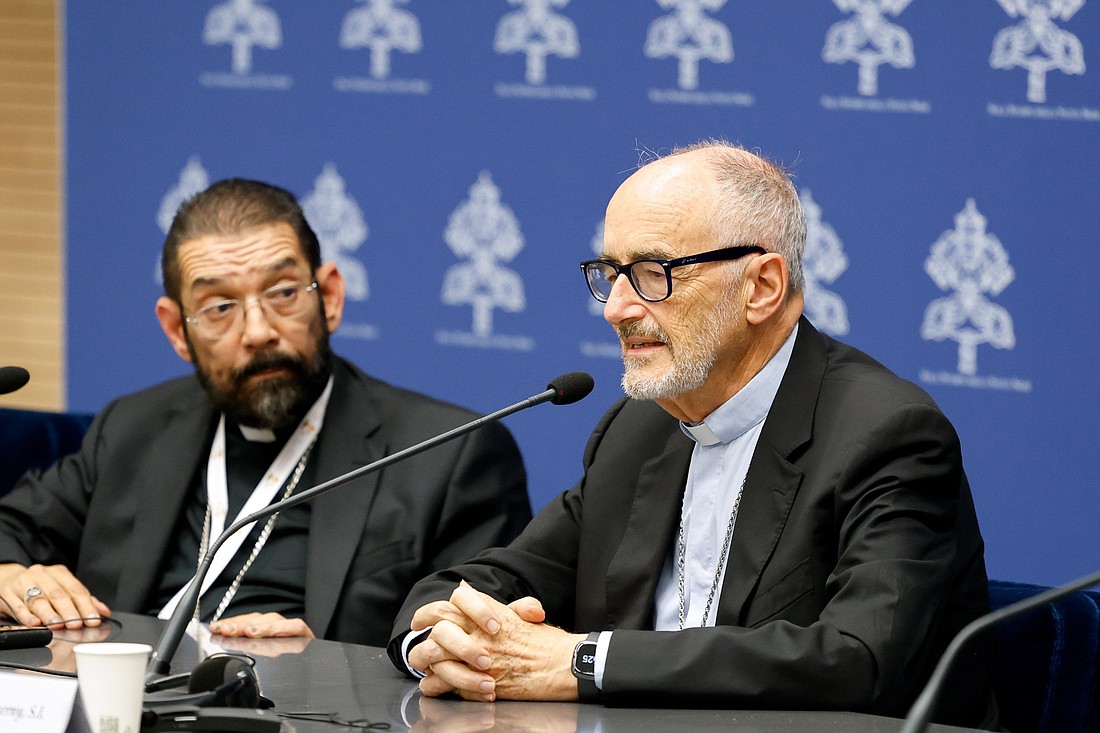 El cardenal Michael Czerny, prefecto del Dicasterio para el Servicio del Desarrollo Humano Integral, habla durante una sesión informativa sobre la asamblea del Sínodo de los Obispos mientras el obispo Daniel E. Flores de Brownsville, Texas, escucha el 19 de octubre de 2023. (Foto CNS/Lola Gómez)