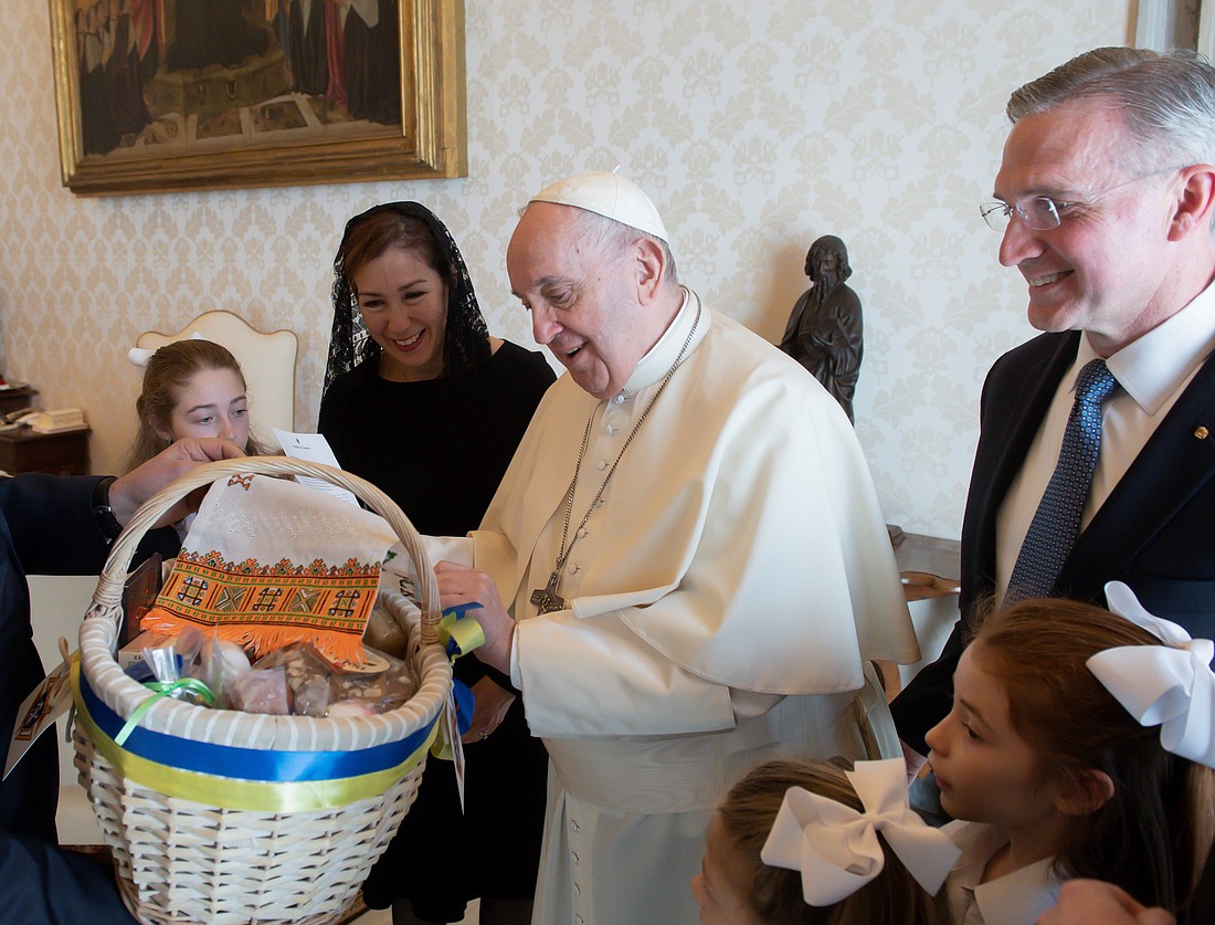 Pope Francis admires an Easter basket presented to him during a private audience granted to Supreme Knight Patrick Kelly and his family at the Vatican April 11, 2022. Kelly recently told OSV News that during that visit with the pope, he shared an insight about the era in which the organization's founder, Blessed Father Michael J. McGivney, evangelized. The culture then "was hostile to the truths of our Catholic faith, and the culture today is perhaps even more hostile," Kelly said. (OSV News photo/Vatican Media)