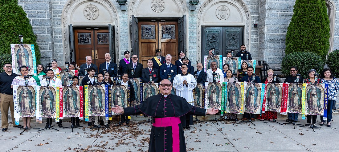 Msgr. Joseph Roldan, Cathedral rector, in forefront, is pictured with the torch bearers in front of St. Mary of the Assumption Cathedral, Trenton, Oct. 28. The torches will travel to parishes throughout the Diocese during November and culminate with a closing Mass Dec. 2 in Our Lady of Guadalupe Parish, Lakewood. Hal Brown photo