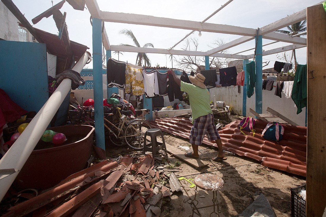 A man hangs clothes inside a badly damaged home in Acapulco, Mexico, Oct. 27, 2023, in the aftermath of Hurricane Otis. Survivors of the Category 5 storm that killed at least 27 people as it devastated Mexico's resort city of Acapulco are searching for acquaintances and necessities and hoping that aid would come quickly in the wake of the hurricane. (OSV News photo/Quetzalli Nicte-Ha, Reuters)