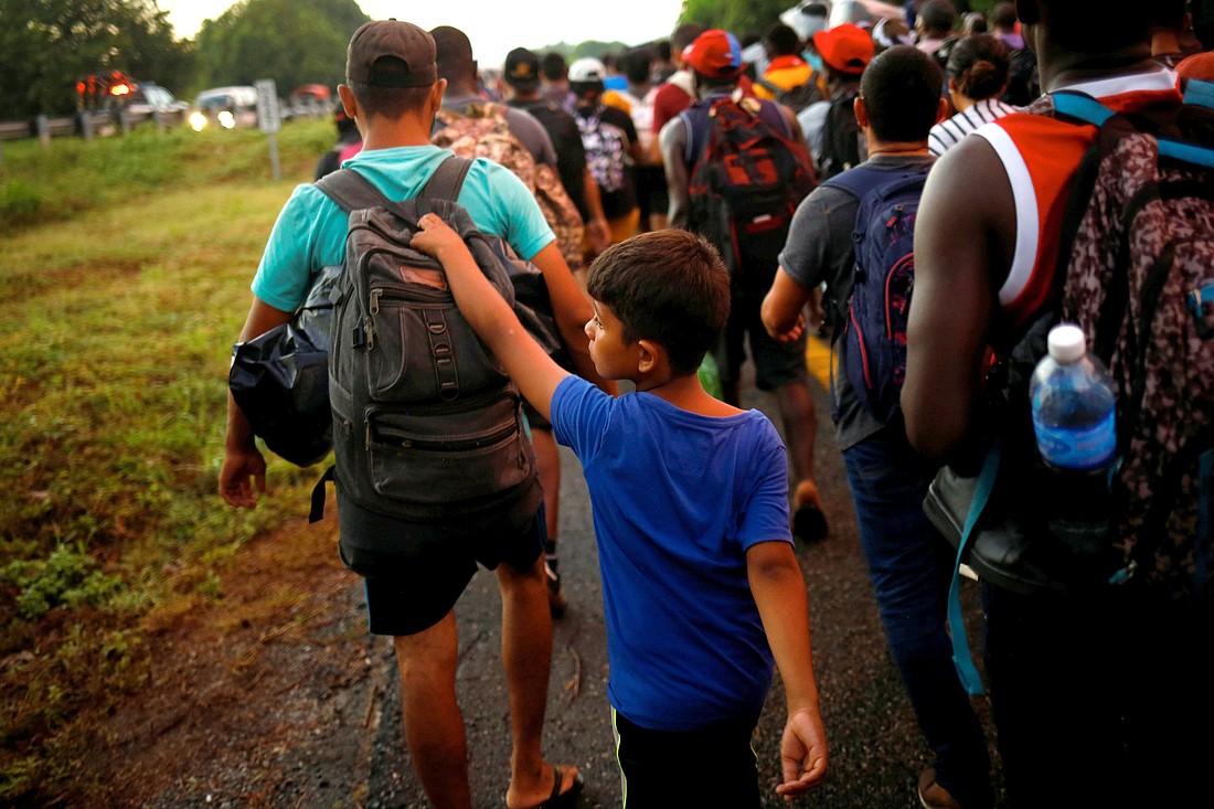 Un joven migrante de Venezuela camina con su hermano mientras se unen a una caravana cerca de Villa Comaltitlán, México, en dirección a la frontera con Estados Unidos el 20 de noviembre de 2021. (Foto CNS/Jose Luis Gonzalez, Reuters)