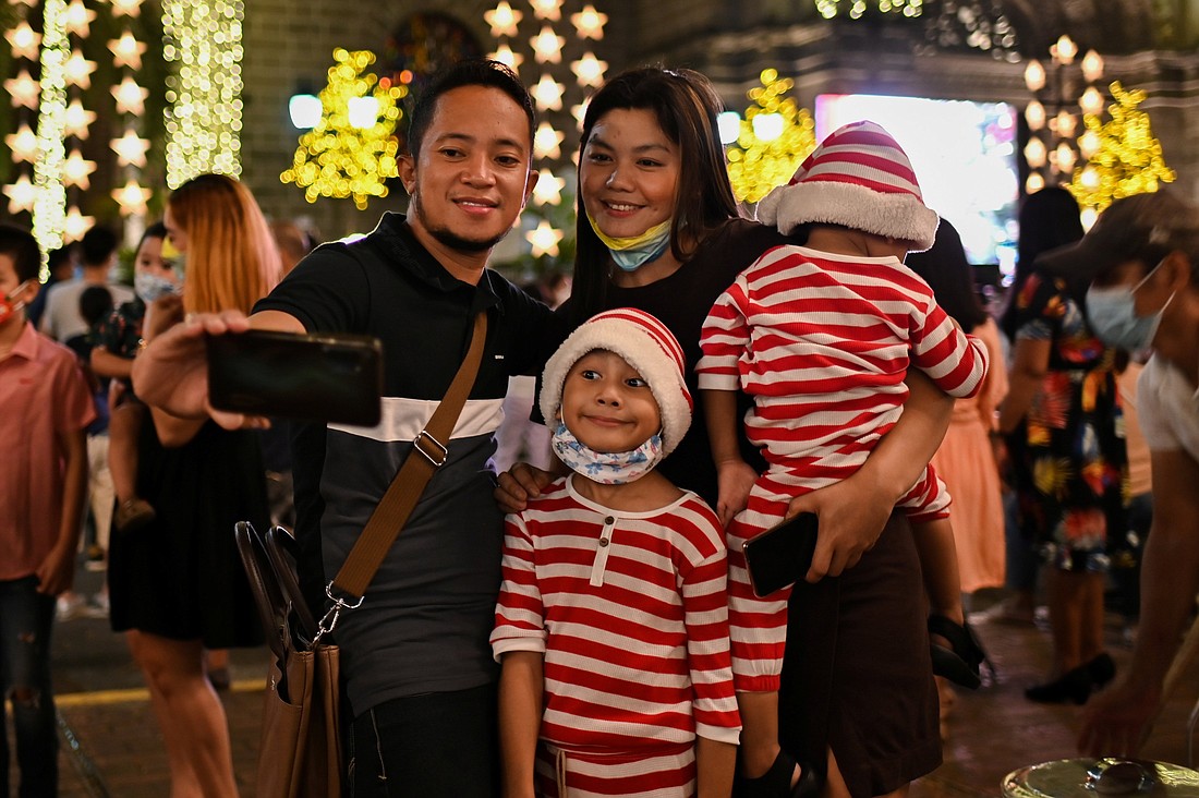 A family takes a picture with a phone in front of the Minor Basilica and Metropolitan Cathedral of the Immaculate Conception before the Christmas Eve mass, in Manila, Philippines, December 24, 2021. (OSV News photo/Lisa Marie David, Reuters)