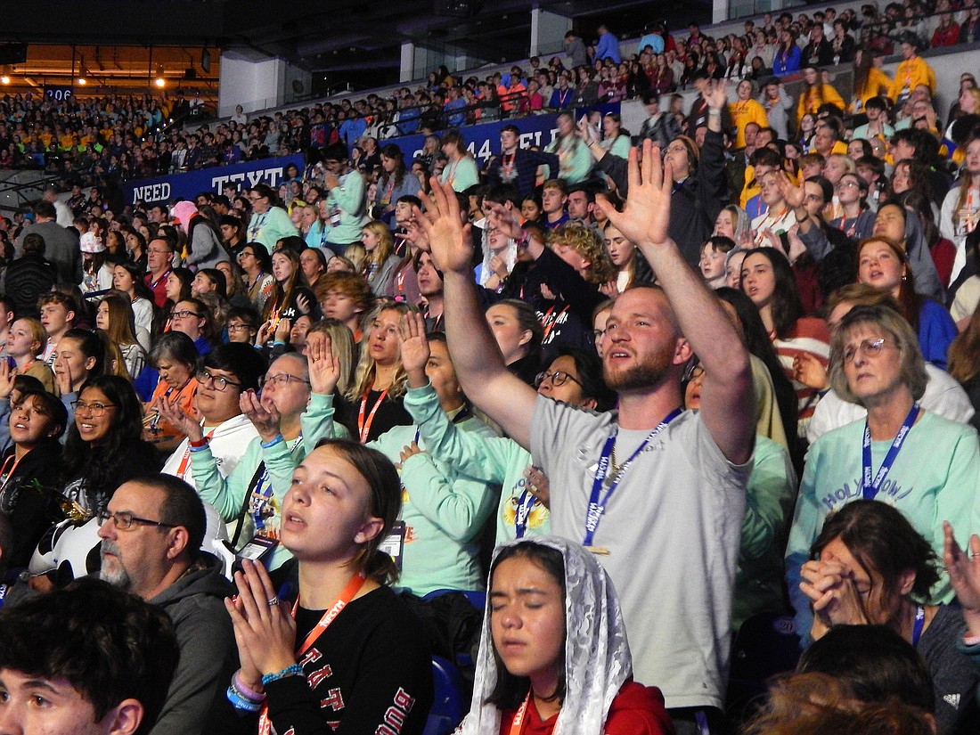 A participant prays during the closing Mass of the National Catholic Youth Conference at Lucas Oil Stadium in Indianapolis Nov 18, 2023. (OSV News photo/Mike Krokos, The Criterion)