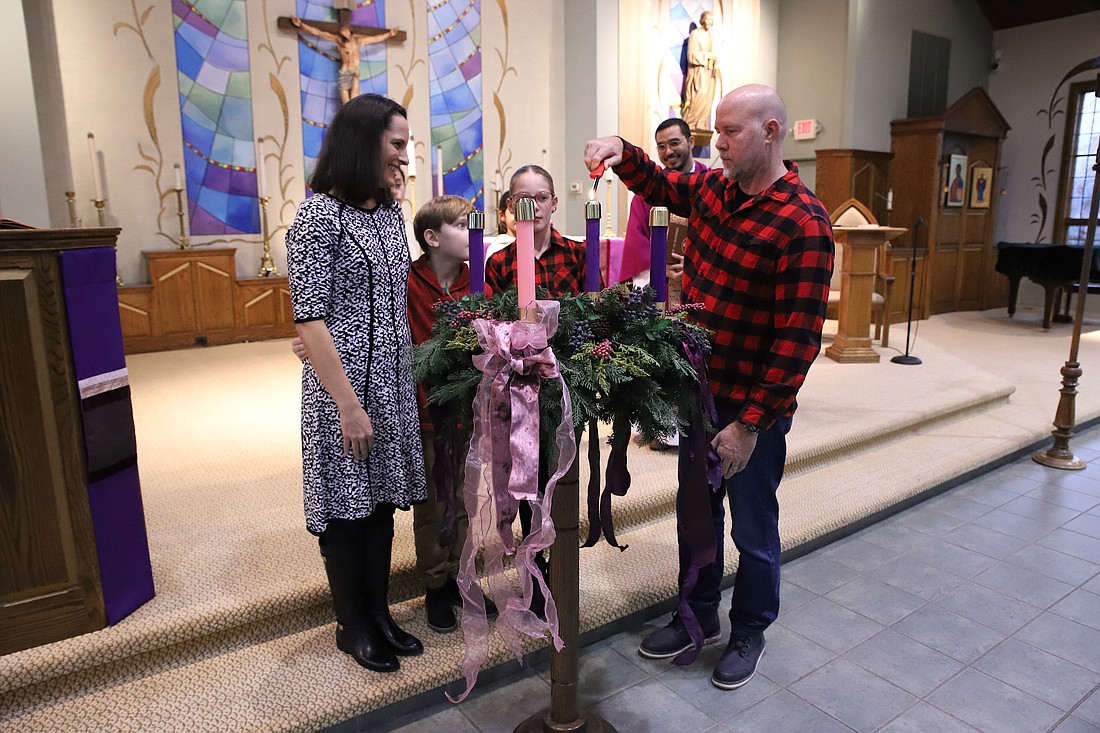 Members of the Block family participate in the lighting of the Advent wreath during Mass on the First Sunday of Advent in St. Catherine of Siena Church, Farmingdale. John Batkowski photo