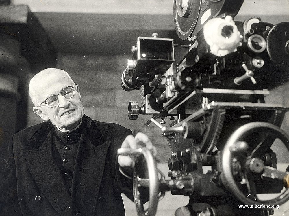 Blessed James Alberione, the founder of the Society of St. Paul whose spirituality is dedicated to evangelizing the culture through modern media,  inspects a camera in this undated file photo. (OSV News photo/courtesy Society of St. Paul General House)