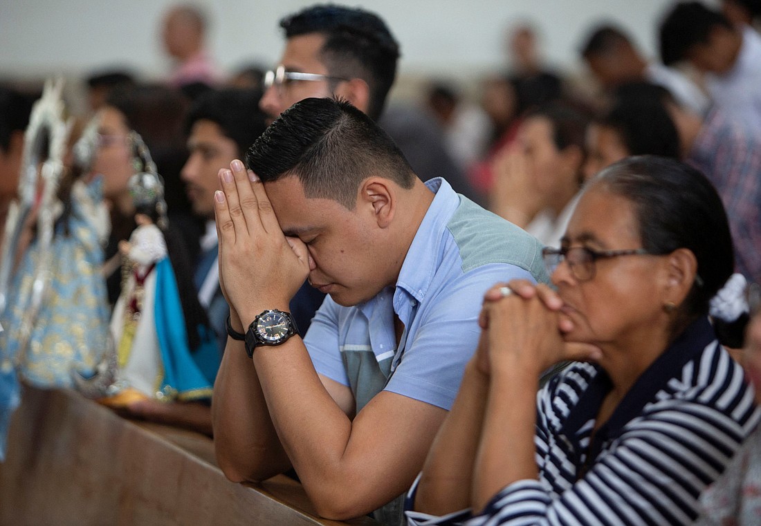 Worshippers pray before a procession on the perimeter of the Metropolitan Cathedral in Managua, Nicaragua, Nov. 26, 2023, as the Nicaragua government banned street processions this year due to unspecified security concerns. (OSV News photo/Maynor Valenzuela, Reuters)