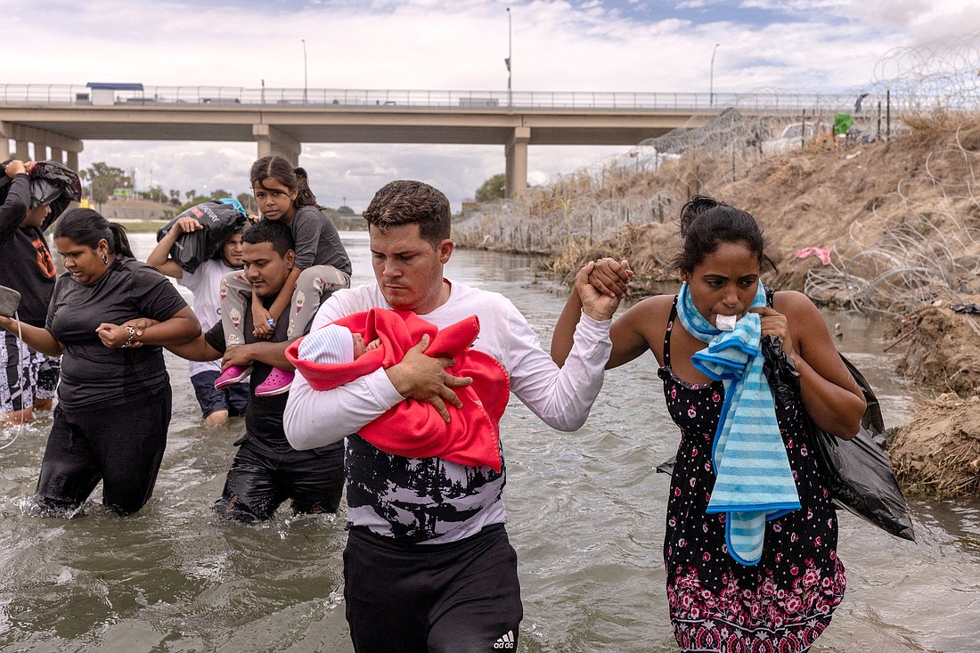 Yusniel, a migrant from Cuba, holds his 10-day-old son, Yireht, and wife, Yanara, as they search for an entry point past a wire fence laden along the bank of the Rio Grande after wading into the United States from Mexico at Eagle Pass, Texas, Oct. 6, 2023. (OSV News photo/Adrees Latif, Reuters)