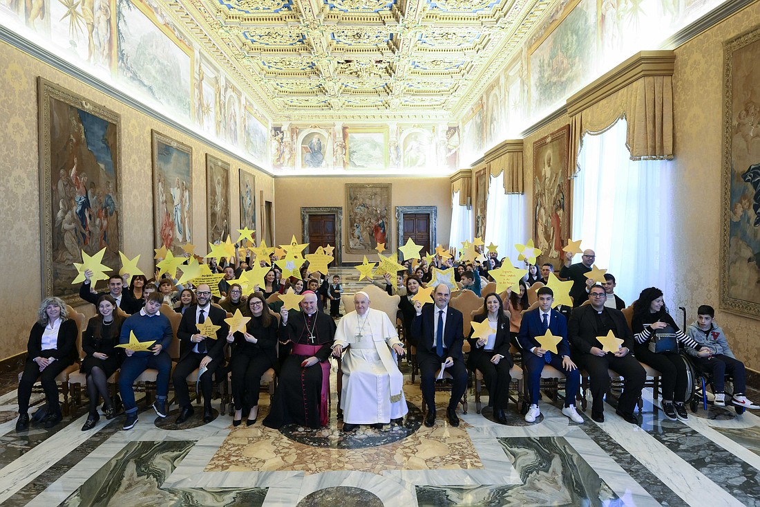 Pope Francis poses for a photo with a delegation from the Italian Catholic Action movement during a meeting at the Vatican Dec. 15, 2023. The group brought paper stars to remember the children who have died from conflicts. (CNS photo/Vatican Media)