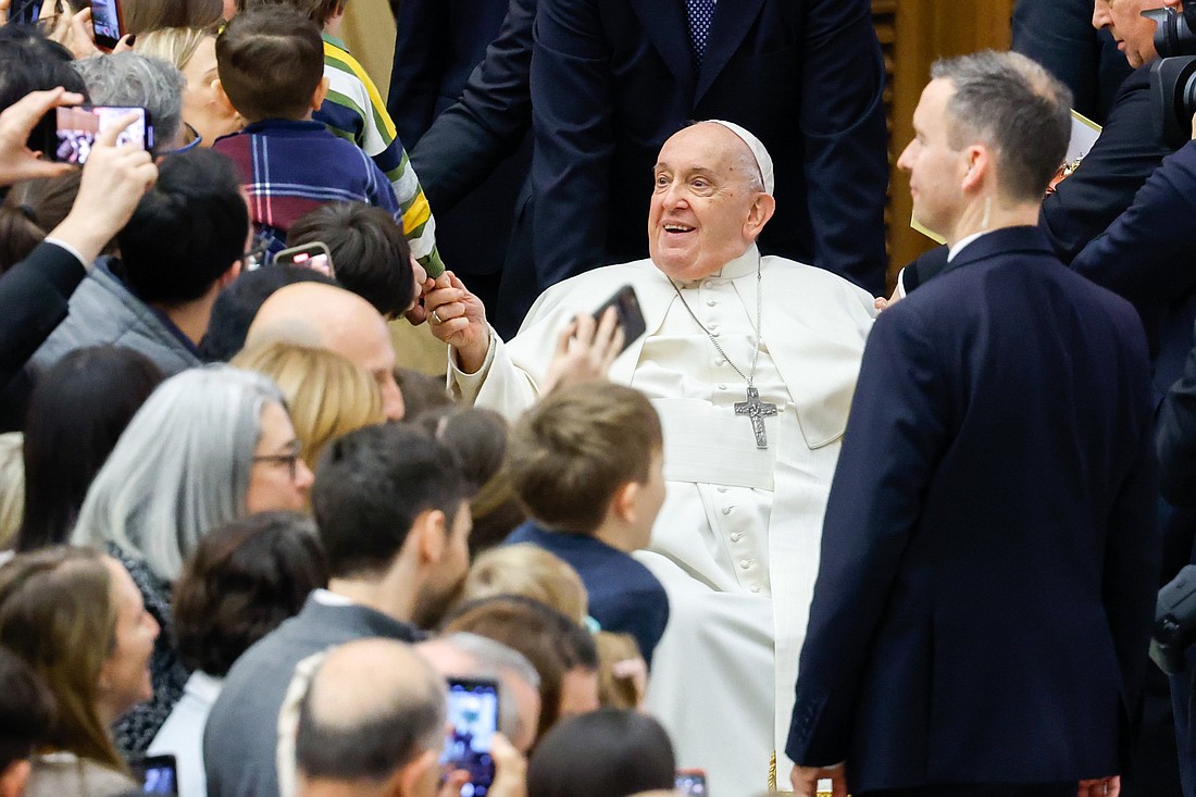 Pope Francis greets Vatican employees and their families and gives chocolates to the children during their annual pre-Christmas meeting in the Paul VI Audience Hall at the Vatican Dec. 21, 2023. (CNS photo/Lola Gomez)