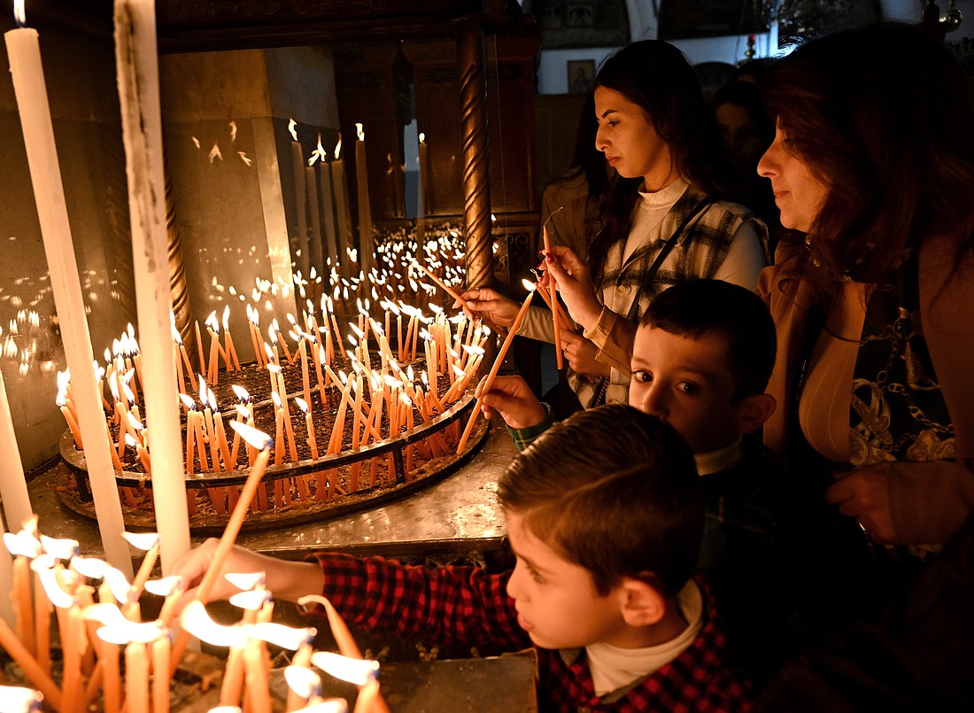 Palestinian Catholics light candles in the Church of the Nativity in Bethlehem, West Bank, Dec. 17, 2023, amid the ongoing Israel-Hamas war. The church is built on what is believed to be the site where Jesus was born. (OSV News photo/Debbie Hill)