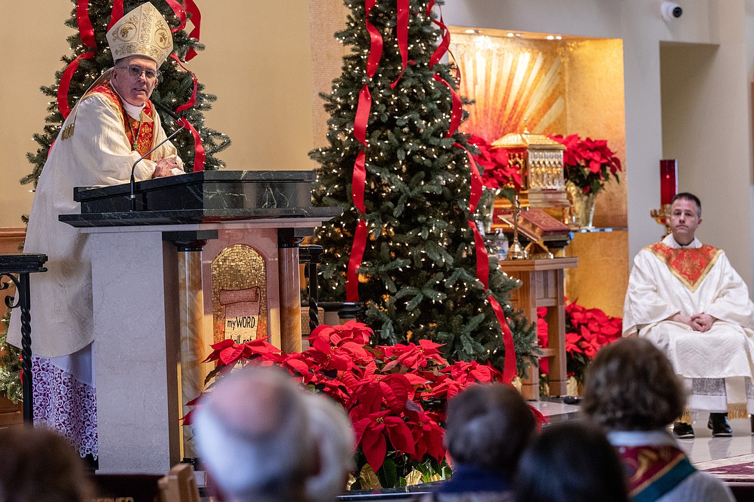 Father Jason Parzynski, parish administrator, seated right, concelebrates the Mass on Christmas morning with the Bishop. Hal Brown photo