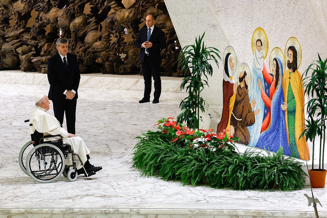 Pope Francis prays in front of a Nativity scene in the Paul VI Audience Hall at the Vatican at the end of his weekly general audience Dec. 27, 2023. (CNS photo/Lola Gomez)