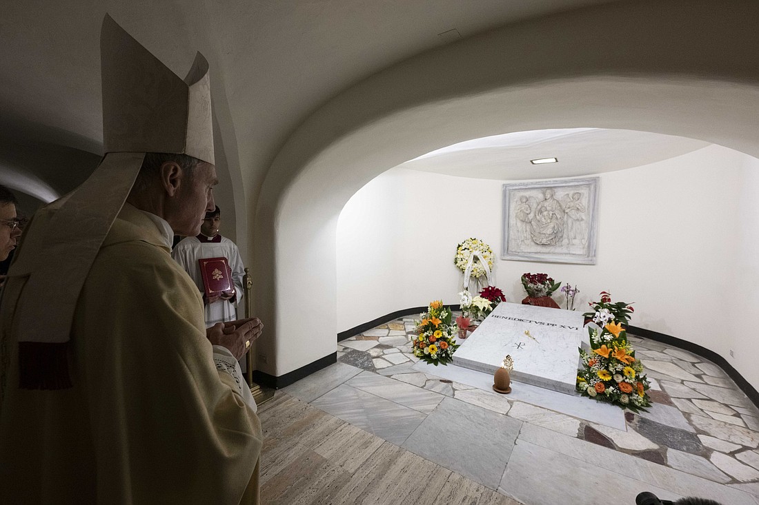 Archbishop Georg Gänswein, former secretary to Pope Benedict XVI, prays at the late pope's tomb in the grotto of St. Peter's Basilica on the first anniversary of the late pope's death Dec. 31, 2023. (CNS photo/Vatican Media)