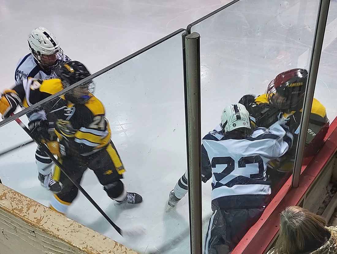 St. John Vianney and Notre Dame players mix it up against the boards during their Jan. 3 contest at Mercer County rink. Rich Fisher photo