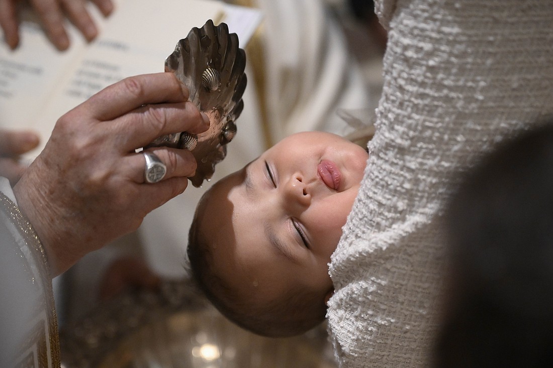 Pope Francis baptizes a baby during Mass in the Sistine Chapel at the Vatican Jan. 7, 2024, the feast of the Baptism of the Lord. (CNS photo/Vatican Media)