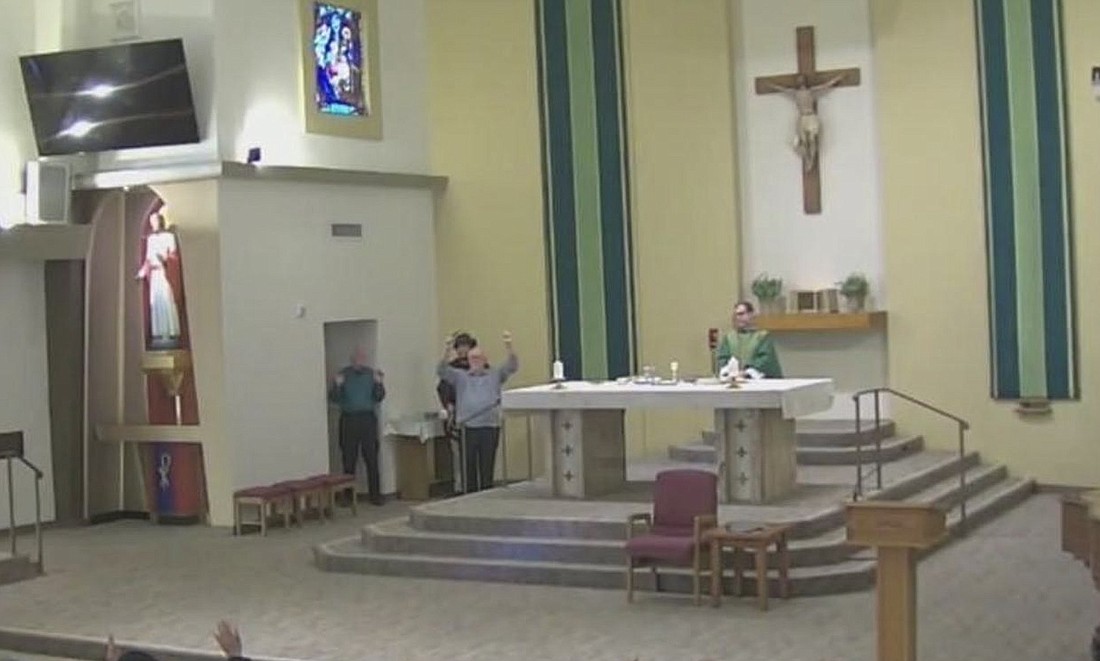 A screenshot from a livestream video shows parishioners raising their hands as law enforcement personnel enter St Joseph Catholic Church during Mass in Placentia, Calif., Jan. 16, 2024. Morning Mass was abruptly interrupted as police barged into the church, telling parishioners to put their hands up as they searched for a man with a gun. The suspect was found "in one of the rear pews," police told OSv News. (OSV News photo/stjosephplacentia.org) Editors: best quality available.