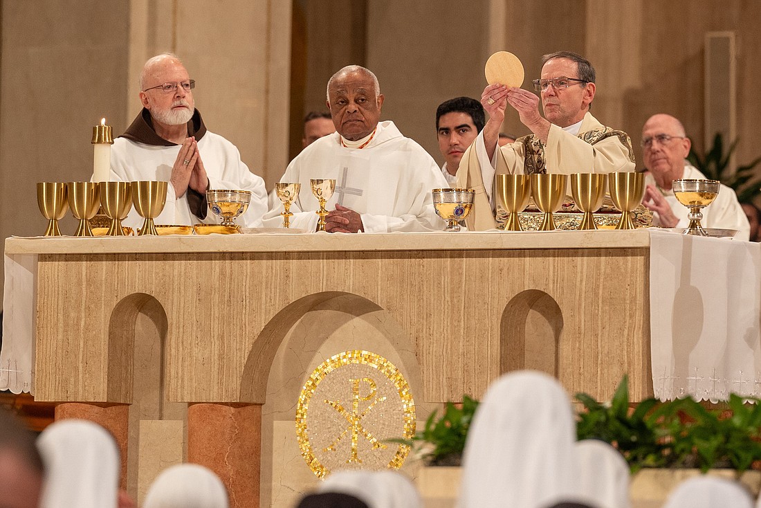 El obispo Michael F. Burbidge de Arlington, Virginia, presidente del Comité para Actividades Pro-Vida de los Obispos Católicos de EE.UU., levanta la hostia durante la Misa de apertura de la Vigilia Nacional de Oración por la Vida el 18 de enero de 2024, en la Basílica del Santuario Nacional de la Inmaculada Concepción en Washington. En la foto también aparecen el cardenal de Boston, Seán P. O'Malley, y el cardenal de Washington, Wilton D. Gregory. (Foto OSV News/Mihoko Owada, Catholic Standard)