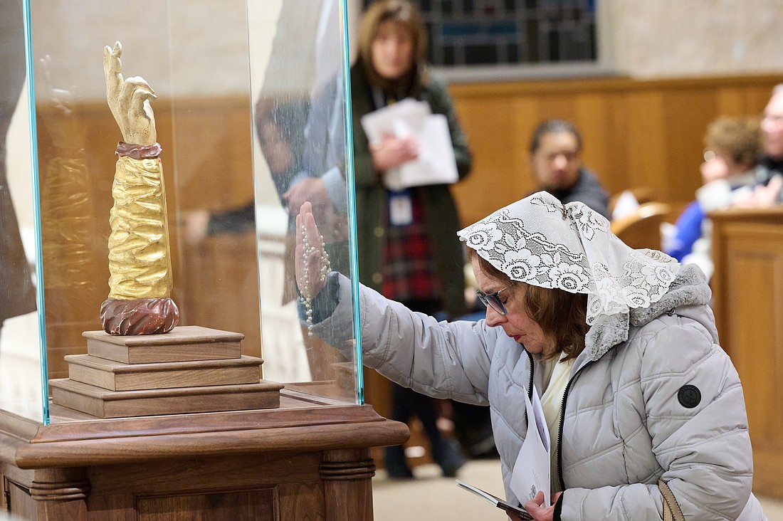 A visitor to St. Dominic Church venerates the relic of St. Jude. Mike Ehrmann photo