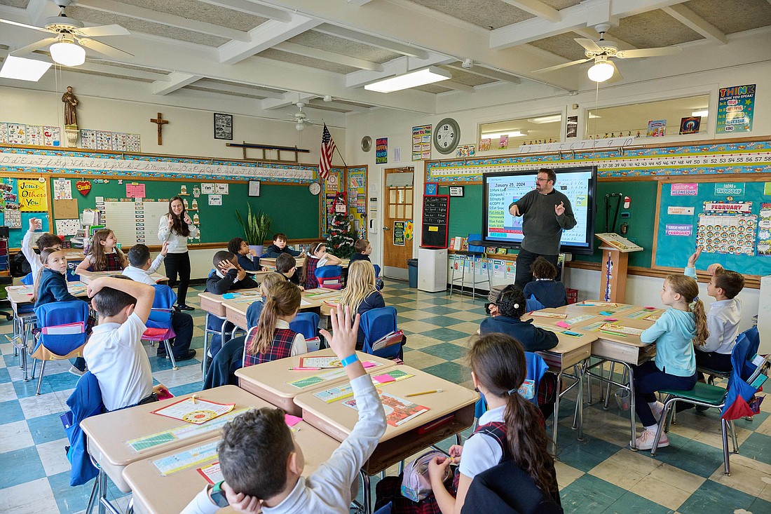 Father Todd Carter visits a classroom in Our Lady of Sorrows School, Hamilton, as part of the school's Catholic Schools Week Celebrate Vocations Day Feb. 1. Mike Ehrmann photo