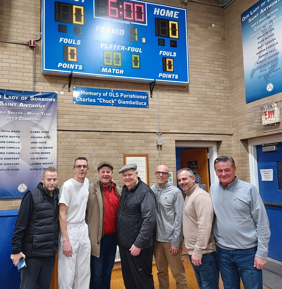 A large contingent from the Chuck Giambelluca Memorial Golf Outing committee was on hand to witness the dedication of the new scoreboard that they donated to Our Lady of Sorrows to honor Giambelluca's name. Included in the gathering are (from left) supporter Doug Moore, OLS Athletic Director Joe Scharibone, board members Tinker Johnson, Tom Dolan, Mike Giambelluca and Jerry Thompson, and supporter Jeff Plunkett. Rich Fisher photo