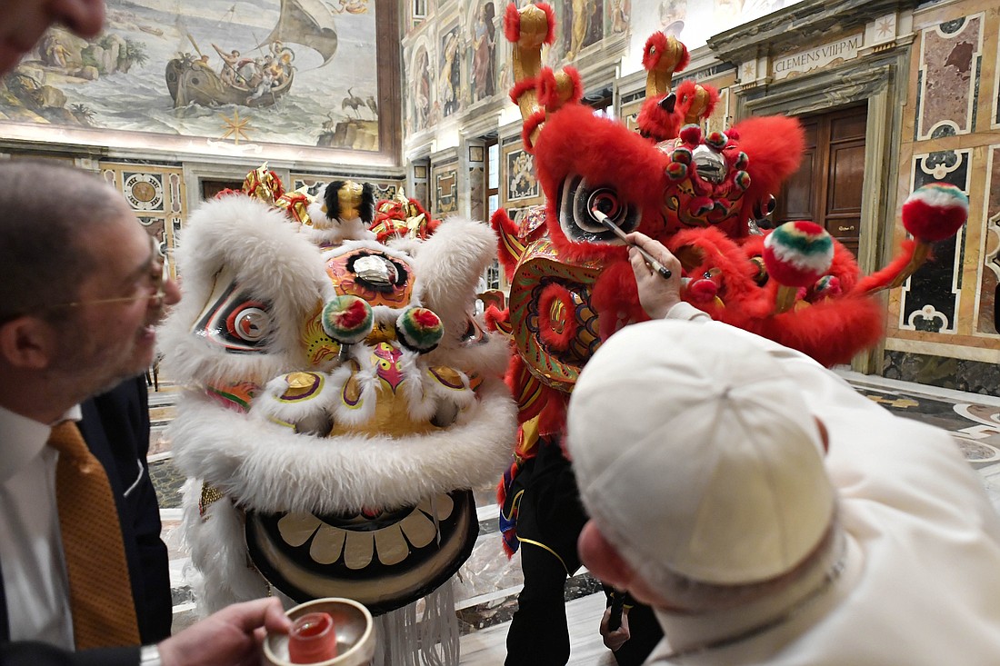 Pope Francis "dots the eyes" of performers dressed as a dragon and lion in a traditional ceremony to symbolically awaken them and welcome in the Chinese New Year during an audience at the Vatican Feb. 2, 2024. The audience included a delegation from the National Federation Italy-China and the Chinese Martial Arts Academy of Vercelli in northern Italy. (CNS photo/Vatican Media).
