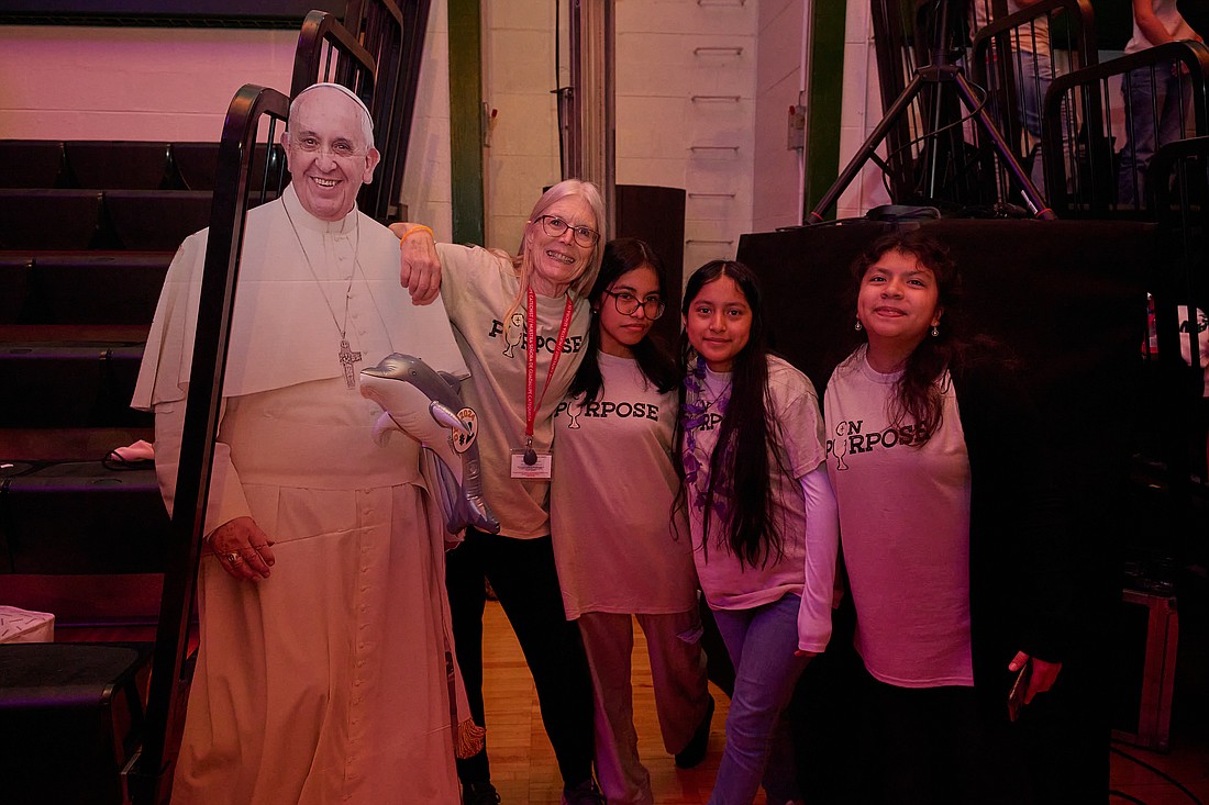 DYC participants get a photo taken with an image of Pope Francis. Mike Ehrmann photo