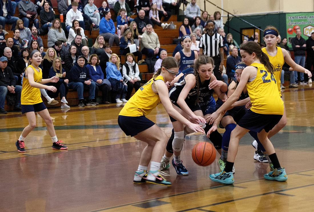 Hamilton Square’s St. Gregory the Great Blue and Hamilton’s St. Raphael’s girls basketball players battle for possession of the ball during the Mercer County CYO Basketball Championship Feb. 18. Joe Moore photo