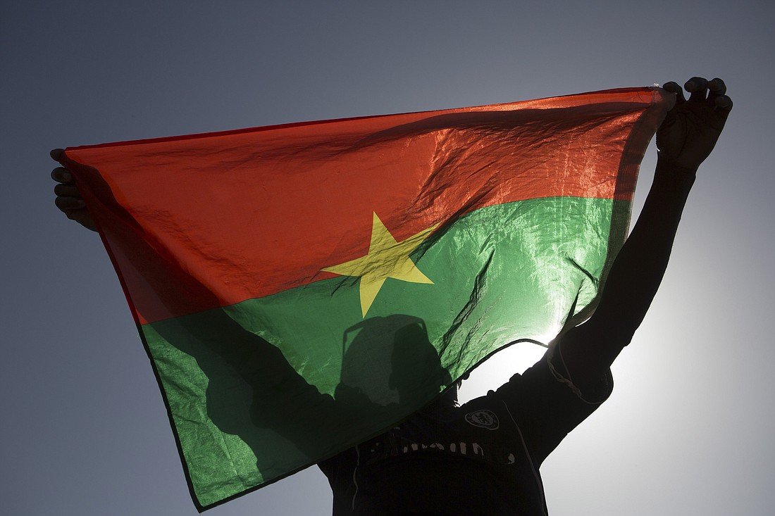 Un manifestante sostiene una bandera de Burkina Faso en Uagadugú, capital de Burkina Faso, en 2014. Al menos 15 personas murieron en un ataque de hombres armados contra católicos reunidos para la misa dominical en un pueblo de Burkina Faso el 25 de febrero de 2024. (Foro OSV News/Joe Penney, Reuters)