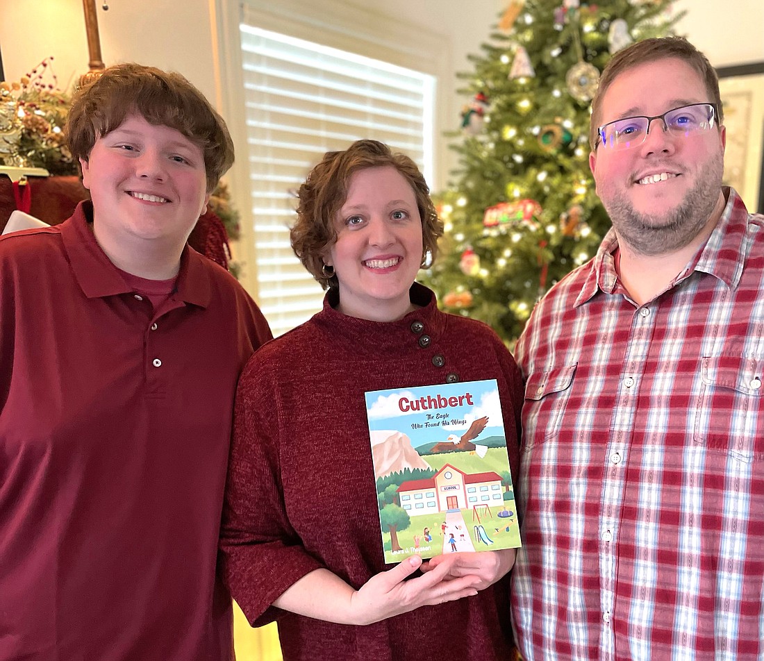 Laura Theissen displays her newly published children's storybook, "Cuthbert: The Eagle Who Found His Wings," with son Lucas and husband Andy at their home in  Columbia, Mo. Laura and her son visited All Saints Catholic School in Manassas, Va., Feb. 1, 2024. Lucas was once a student at the school in the Diocese of Arlington, and during the visit his mother donated a copy of her book to each classroom. (OSV News photo/courtesy Theissen family)