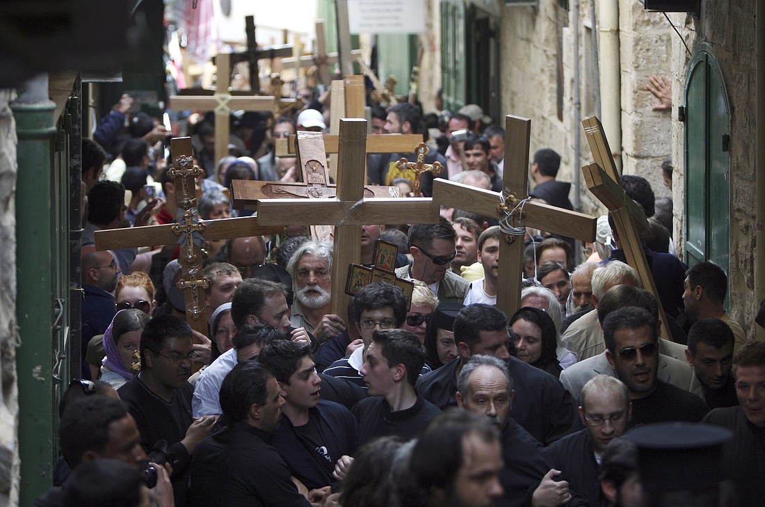 Pilgrims are pictured in a file photo carrying crosses to the Church of the Holy Sepulcher in Jerusalem's Old City. The Franciscan Custody of the Holy Land is in charge of most pilgrimage sites, but with no pilgrims and with churches empty for the annual Good Friday collection, officials fear they will not be able to pay teachers, maintain Franciscan sanctuaries or support tuition subsidies. (CNS photo/Ammar Awad, Reuters)