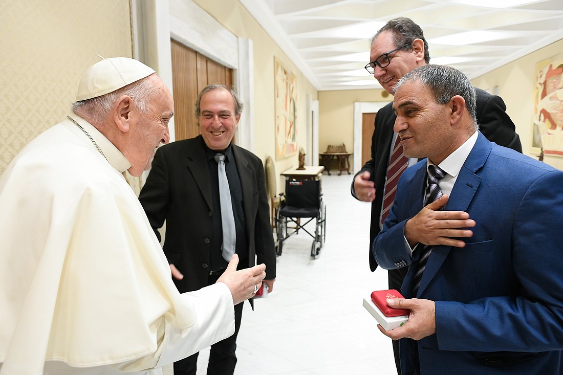 Pope Francis meets with two fathers who both lost their daughters in violent conflicts, Bassam Aramin from Palestine, right, and Rami Elhanan from Israel, before his weekly general audience in the Paul VI Audience Hall at the Vatican March 27, 2024. In the center is Lorenzo Fazzini, director of the Vatican publishing house. (CNS photo/Vatican Media)