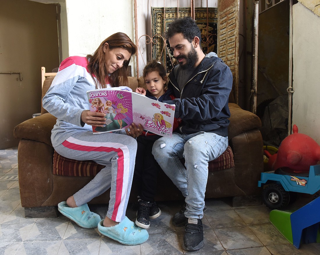 Parents are pictured in a file photo reading to their daughter. (OSV News  photo/CNS file, Debbie Hill)