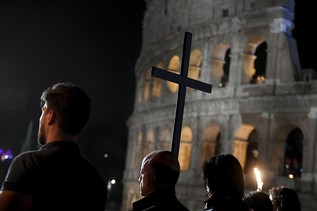 People representing different facets of the church and society carry the cross in procession during the Good Friday Way of the Cross service at Rome's Colosseum March 29, 2024. (CNS photo/Vatican Media)